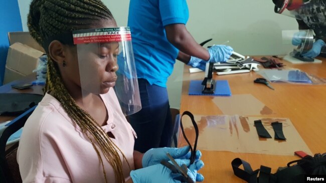 FILE - Workers prepare face shields from recycled plastics at the Zaidi Recyclers workshop in Dar es Salaam, Tanzania, May 27, 2020.