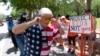 Pripadnik NRA zatvara uši prstima dok hoda pored demonstranata, tokom godišnje konvencije NRA, u Hjustonu, Teksas, 27. maja 2022.