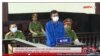 Trần Hoàng Huấn tại phiên tòa ở Tiền Giang ngày 5/5/2022. Photo chụp từ ANTV.