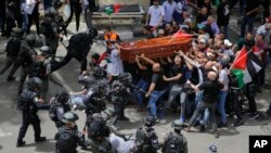 Peti jenazah wartawan Al Jazeera Shireen Abu Akleh sempat terjatuh saat polisi Israel menyerang pelayat pada upacara pemakamannya di Yerusalem timur (13/5).