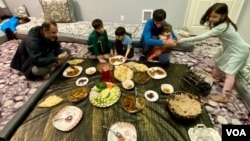 Najeebullah enjoys a family meal with relatives in Seattle. The daughter he saved at the Abbey Gate is on the back left, asleep on the couch. (Carolyn Presutti/VOA)