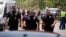 Police officers walk near Robb Elementary School following a mass shooting in Uvalde, Texas, May 24, 2022.