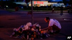 A person pays his respects outside the scene of a shooting at a supermarket, in Buffalo, N.Y., May 15, 2022.
