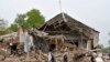 Men walk past a damaged building after Russian shelling in Soledar, Donetsk region, Ukraine, Wednesday, May 18, 2022. (AP Photo)