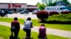 People pray outside the scene of a shooting at a supermarket, in Buffalo, NY, May 15, 2022.