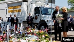 Le président américain Joe Biden et la première dame Jill Biden, qui tient un bouquet de 21 fleurs blanches, rendent hommage au mémorial de l'école primaire Robb, où un tireur a tué 19 enfants et deux enseignants, à Uvalde, au Texas, le 29 mai 2022. 