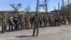 俄罗斯国防部发布的视频截图显示，乌克兰军人从马里乌波尔亚速钢铁厂走出投降，在俄罗斯士兵前站成一排。（2022年5月18日）