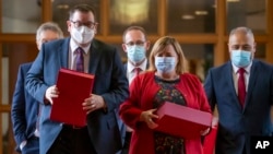 New Zealand Finance Minister Grant Robertson, front left, on his way to present his budget to Parliament with ministers, from left, David Parker, obscured, Andrew Little, Megan Woods, and Peeni Henare, right, in Wellington, New Zealand, May 19, 2022. 