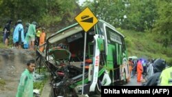 Warga memeriksa bus setelah jatuh menewaskan 13 orang dan melukai puluhan lainnya di Bantul, Yogyakarta, sebagai ilustrasi. (Foto: AFP/Dhita Wardhani)