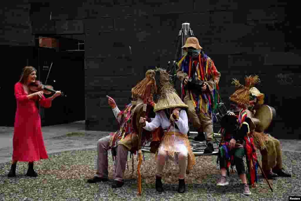 Doireann Glackin plays the fiddle next to a group of Mummers as they perform in Smithfield Square to highlight the upcoming Smithfield Fleadh traditional music and folk festival in Dublin, Ireland, May 31, 2022.