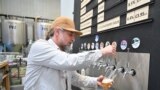 A worker pours a pint of beer at Pressure Drop Brewery, in north London, on May 21, 2022. 