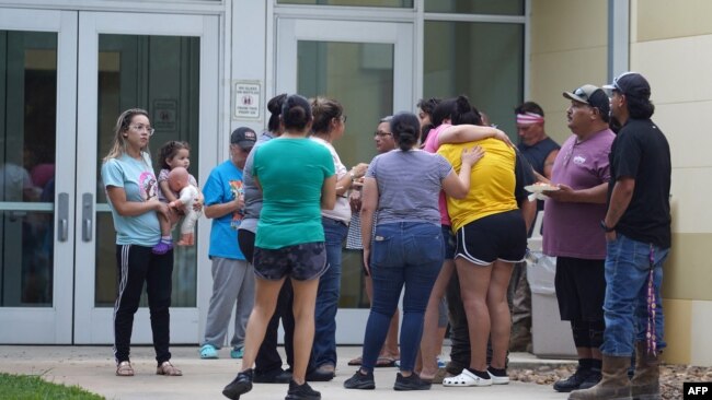 Các gia đình tập trung bên ngoài trường tiểu học Robb ở Uvalde, Texas, sau khi xảy ra vụ xả súng vào ngày 24/5/2022. (Photo AFP/Allison Dîner)