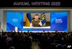 Ukrainian President Volodymyr Zelenskyy is seen on a screen as he addresses the audience from Kyiv during the World Economic Forum in Davos, Switzerland, May 23, 2022.