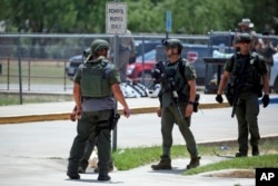 Law enforcement personnel stand outside Robb Elementary School following a shooting, Tuesday, May 24, 2022, in Uvalde, Texas. (AP Photo/Dario Lopez-Mills)