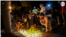 Velas iluminan los carteles con los rostros de algunas de las víctimas de la explosión en el hotel Saratoga. Asistentes a la vigilia prenden velas para conmemorar a las víctimas de la explosión causada, aparentemente, por una fuga de gas. 