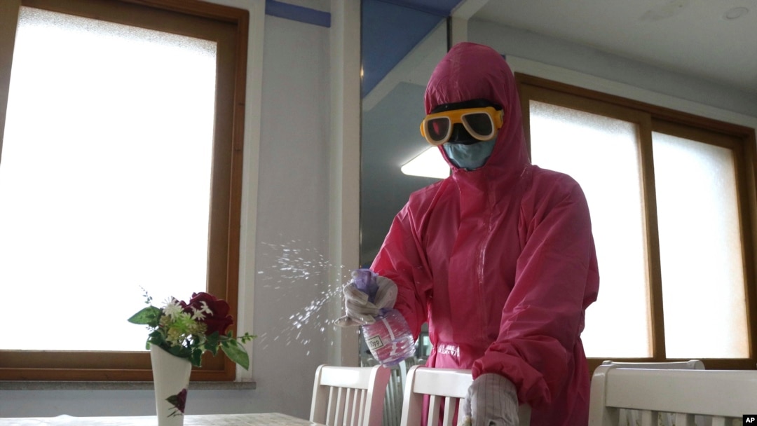 FILE - An employee of Pyongyang Dental Hygiene Products Factory disinfects the floor of a dinning room as the state increased measures to stop the spread of illness in Pyongyang, North Korea on May 16, 2022.