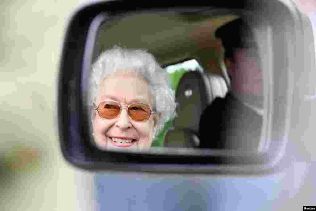 Britain's Queen Elizabeth is reflected in the mirror of a car, as she watches horses competing on the second day of the Royal Windsor Horse Show and Platinum Jubilee Celebration in Windsor, Britain.