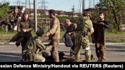 A still image taken from a video released by Russian Defence Ministry shows what it claims are service members of Ukrainian forces, who left the besieged Azovstal steel plant, being searched by the pro-Russian military in Mariupol, Ukraine. Video released May 17, 2022.