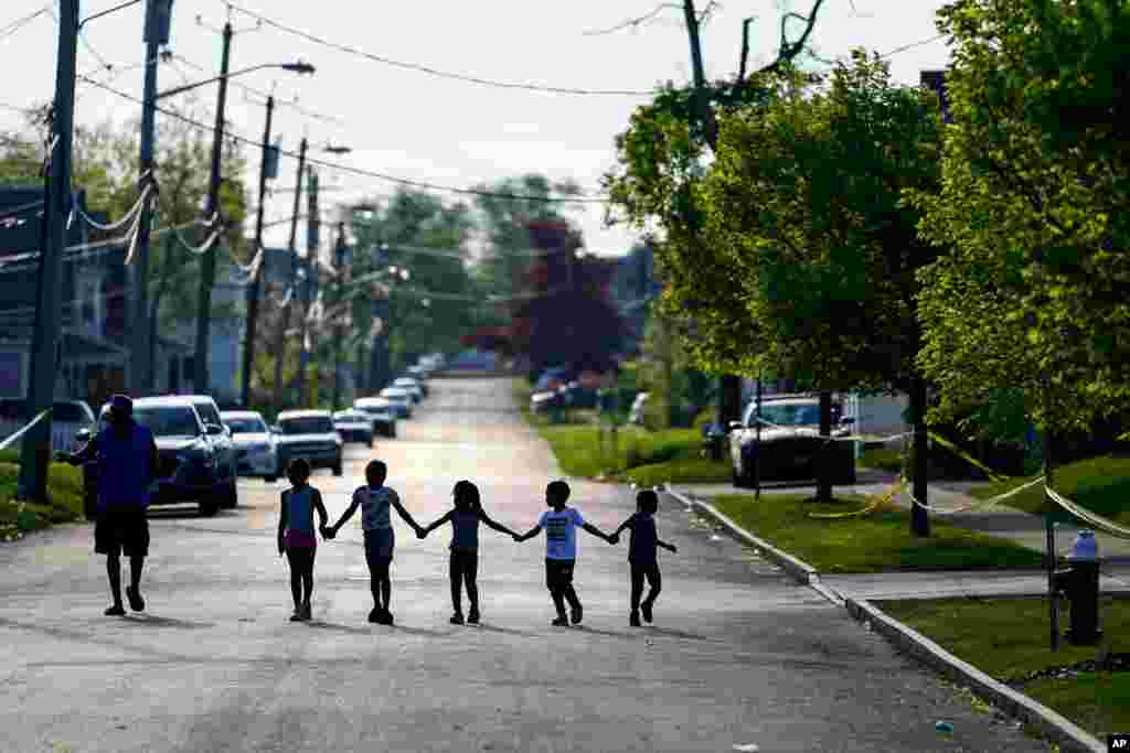Children walk hand in hand near the scene of a shooting at a supermarket in Buffalo, New York.