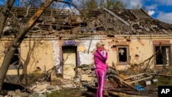 Iryna Martsyniuk, 50, stands next to her house, which was heavily damaged in a Russian bombing in Velyka Kostromka village, Ukraine, May 19, 2022.