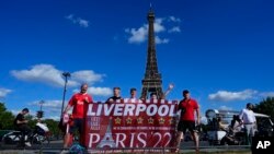 Liverpool fans pose for a photograph in front of the Eiffel Tower Paris.