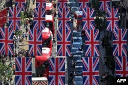 Bus dan taksi Red London lewat di bawah bendera Union, untuk merayakan Jubilee Platinum Ratu Elizabeth, di Regent Street di pusat kota London. (Foto: AFP)