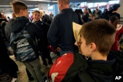 Anak yatim piatu Ukraina menunggu penerbangan ke Inggris Raya di bandara Chopin, di Warsawa, Polandia, 23 Maret 2022. (Foto: AP)
