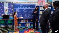 FILE - A student gives Vice President Kamala Harris a card at the Armand J. Brinkhaus Community Library, before Harris delivered remarks on accessible internet in Sunset, La., March 21, 2022.