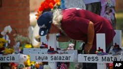 Seorang pria mencium salib Layla Salazar di luar Sekolah Dasar Robb untuk menghormati para korban yang tewas dalam penembakan di sekolah minggu ini di Uvalde, Texas, 28 Mei 2022. (Foto: AP)