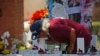 A man kisses the cross of Layla Salazar at a memorial outside Robb Elementary School to honor the victims killed in this week's school shooting in Uvalde, Texas, May 28, 2022.