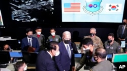 U.S. President Joe Biden, center, and South Korean President Yoon Suk Yeol, center left, greet the members of the Combat Operations Floor at the Osan Air Base, Sunday, May 22, 2022, in Pyeongtaek, South Korea. (AP Photo/Evan Vucci)