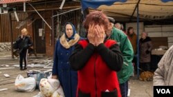 2022年4月28日，在逃离村庄几个小时后，一位女士在哈尔科夫郊外掩面哭泣说：“我以为我死了。”(美国之音博夏特拍摄)