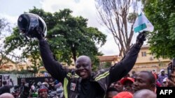 Kunle Adeyanju célèbre avec ses supporters après son arrivée au Rotary club d'Ikeja à Lagos le 29 mai 2022, après un voyage de 41 jours depuis Londres, en moto, pour collecter des fonds et sensibiliser à la campagne End Polio.