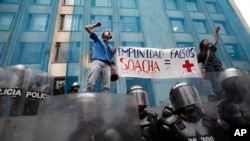 Estudiantes sostienen un cartel durante una protesta contra oficiales que eliminaron a civiles en el caso conocido por "falsos positivos", en Bogotá, Colombia, el 7 de abril de 2011. 