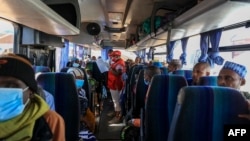 FILE - A Red Cross worker takes roll call in one of the many buses planned for the return home of Central African Republic refugees in Gado, Cameroon, Dec. 2, 2020.