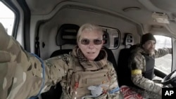 Yuliia Paievska, known as Taira, and her driver Serhiy sit in a vehicle in Mariupol, Ukraine on March 9, 2022. She last appeared on March 21 on Russian television as a captive, handcuffed and with bruises on her face.