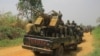 Arquivo: Veículos de soldados das FARDC (Forças Armadas da República Democrática do Congo) escoltam veículos civis que transportam mercadorias de Beni para Komanda na estrada nacional, 19 de Março de 2022