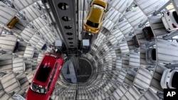 This file photo shows cars ready for delivery at a 'car tower' at the Volkswagen vehicle factory in Wolfsburg, Germany, Monday, Nov. 8, 2021. (AP Photo/Michael Sohn, file)