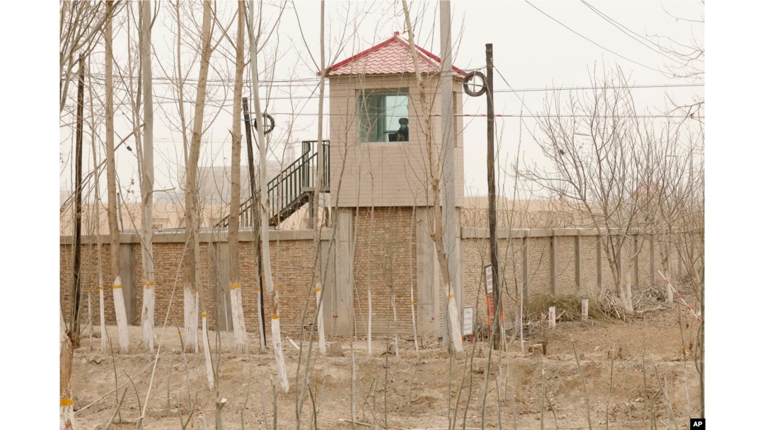 FILE - A security person watches from a guard tower around a detention facility in Yarkent County in northwestern China's Xinjiang Uyghur Autonomous Region on March 21, 2021.