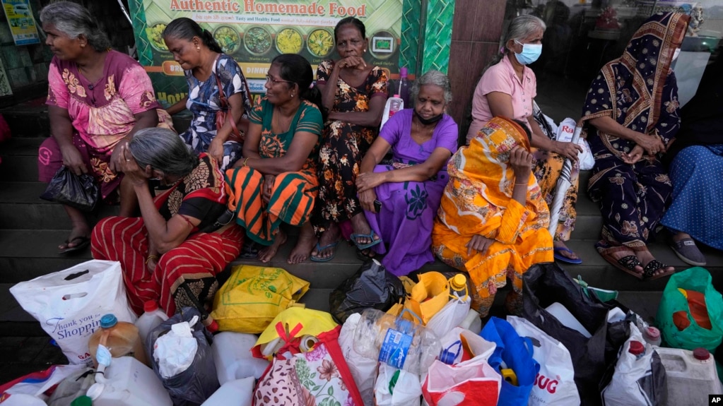 Women wait near an empty fuel station hoping to buy kerosene for cooking, in Colombo, Sri Lanka, May 26, 2022.