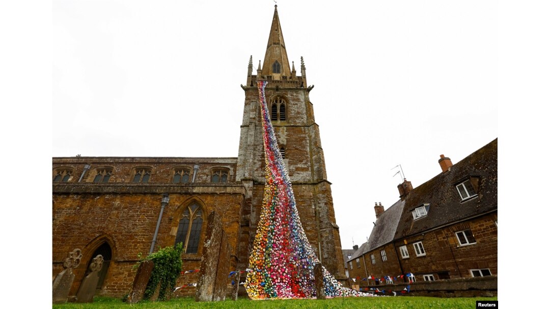 "Flower Tower" yang terdiri dari lebih 4.300 bunga rajutan dan kaitan buatan tangan terlihat di Gereja All Saints, menjelang perayaan Platinum Jubilee untuk Ratu Elizabeth dari Inggris, di Middleton Cheney, Inggris, 26 Mei 2022. (Foto: Reuters)