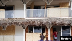Men board up windows as they prepare for the arrival of Hurricane Agatha, in Puerto Escondido, Oaxaca state, Mexico, May 29, 2022.