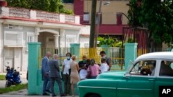 Diplomáticos de varios países esperan fuera del edificio del tribunal donde se lleva a cabo un juicio contra los artistas cubanos Luis Manuel Otero Alcántara y Maykel Castillo en La Habana, Cuba, el lunes 30 de mayo de 2022. (AP Foto/Ramón Espinosa)