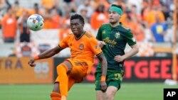 Houston Dynamo defender Teenage Hadebe, left, brings down the ball in front of Portland Timbers forward Jarosław Niezgoda (11) during the second half of an MLS soccer match Saturday, April 16, 2022, in Houston. (AP Photo/Michael Wyke)