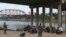 Los migrantes que cruzaron el río Bravo hacia EEUU están bajo la custodia de miembros de la Guardia Nacional mientras esperan la llegada de los agentes de la Patrulla Fronteriza en Eagle Pass, Texas, el 20 de mayo de 2022.