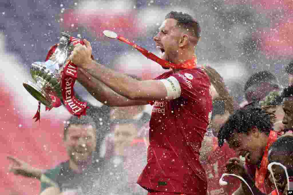 Liverpool&#39;s Jordan Henderson celebrates with the trophy at the end of the English FA Cup final soccer match between Chelsea and Liverpool, at Wembley stadium in London, May 14, 2022.