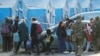 Civili evakuisani iz čeličane Azovstal hodaju u pratnji predstavnka Međunarodnog komiteta crvenog krsta i osoblja UN, uz prisustvo ruskih vojnika, u prihvatnom centru u selu Bezimene, tokom rata Rusije u Ukrajini, u regionu Donjetska, 6. maja 2022.