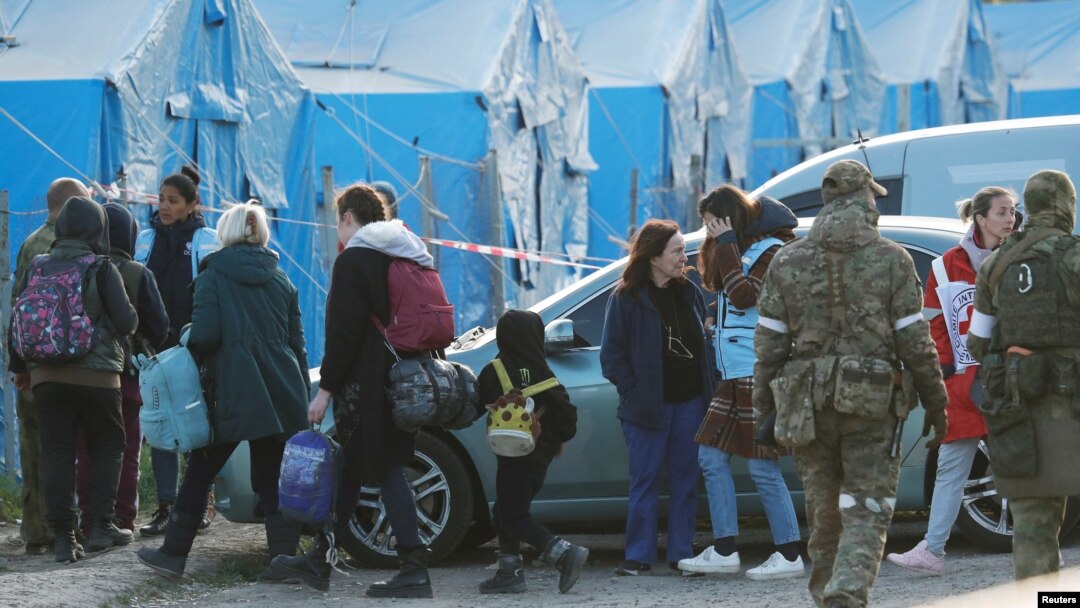 Civili evakuisani iz čeličane Azovstal hodaju u pratnji predstavnka Međunarodnog komiteta crvenog krsta i osoblja UN, uz prisustvo ruskih vojnika, u prihvatnom centru u selu Bezimene, tokom rata Rusije u Ukrajini, u regionu Donjetska, 6. maja 2022.