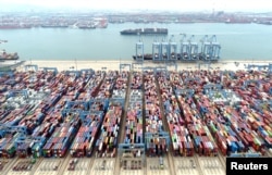 FILE - An aerial view shows containers and cargo vessels at the Qingdao port in Shandong province, China, May 9, 2022. (China Daily via Reuters)