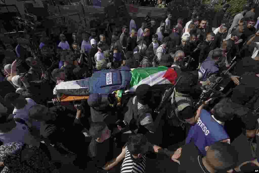 Palestinian militants carry the body of Shireen Abu Akleh, a journalist for Al Jazeera network, in the West Bank town of Jenin. The well-known Palestinian reporter was shot and killed while covering an Israeli raid, the Palestinian health ministry said. 